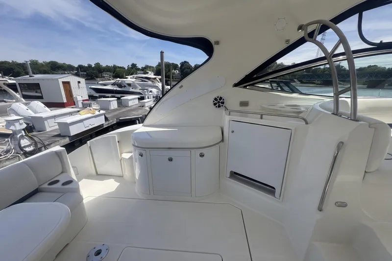 Slide: The Image of 2006 Cruisers Yachts 520 Express interior with sleek white seating and cabinetry at marina. - 17