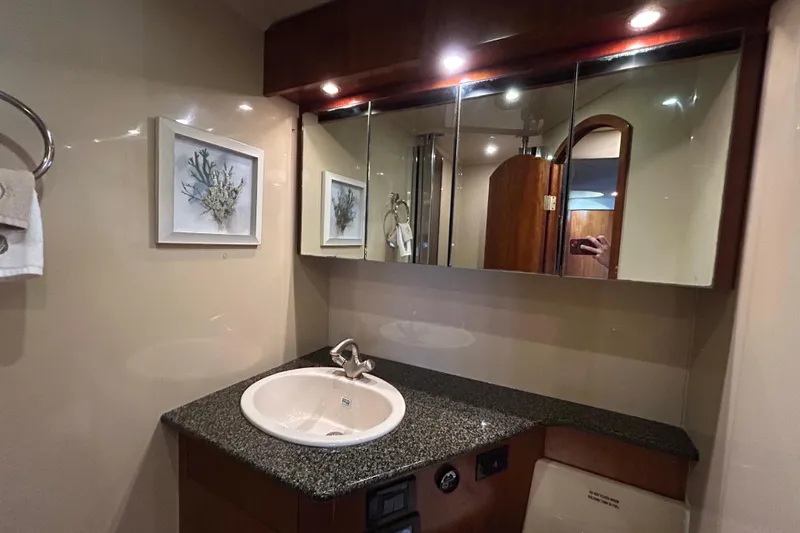 Slide: The Image of Luxurious bathroom in 2006 Cruisers Yachts 520 Express with granite countertop and mirrored cabinets. - 32