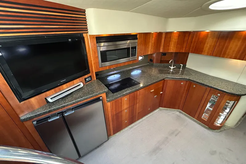 Slide: The Image of Luxurious 2006 Cruisers Yachts 520 Express kitchen with modern appliances and sleek wood cabinetry. - 25