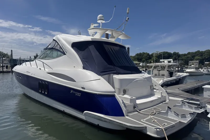Slide: The Image of 2006 Cruisers Yachts 520 Express docked at marina under clear blue sky. - 11