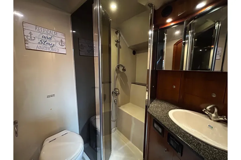 Slide: The Image of Luxurious 2006 Cruisers Yachts 520 Express bathroom with shower, sink, and nautical decor. - 35