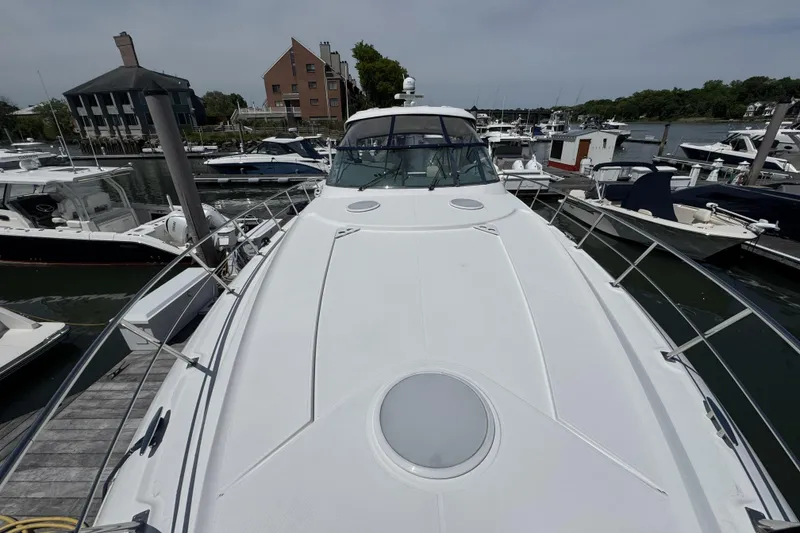 Slide: The Image of 2006 Cruisers Yachts 520 Express docked at marina, showcasing sleek design and spacious deck. - 36