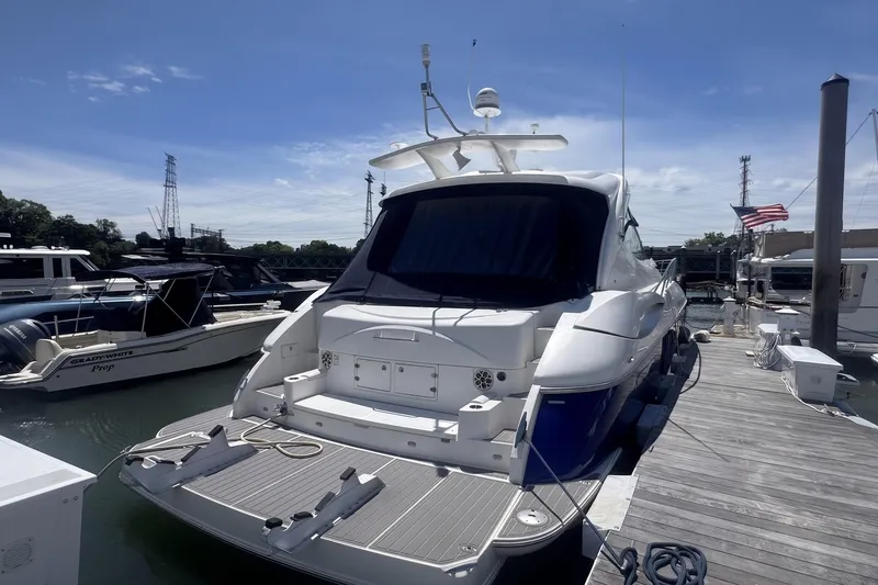 Slide: The Image of 2006 Cruisers Yachts 520 Express docked at marina under clear blue sky. - 12