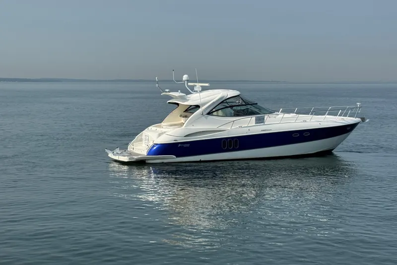 Slide: The Image of 2006 Cruisers Yachts 520 Express on calm water, showcasing sleek design and luxury features. - 4