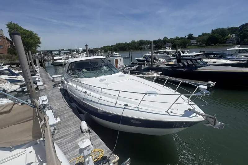 Slide: The Image of 2006 Cruisers Yachts 520 Express docked at a marina under clear skies. - 10