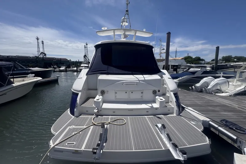 Slide: The Image of 2006 Cruisers Yachts 520 Express docked at marina, rear view with swim platform. - 14