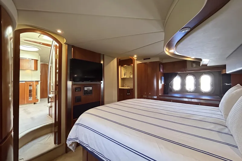 Slide: The Image of Luxurious 2006 Cruisers Yachts 520 Express cabin interior with elegant wood finishes and cozy bedding. - 30