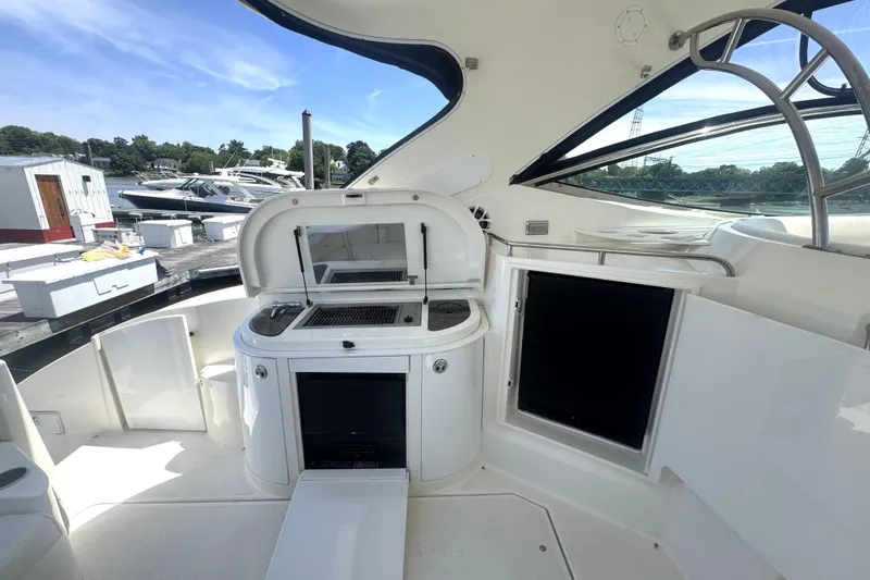 Slide: The Image of 2006 Cruisers Yachts 520 Express interior with kitchenette and outdoor seating area. - 18