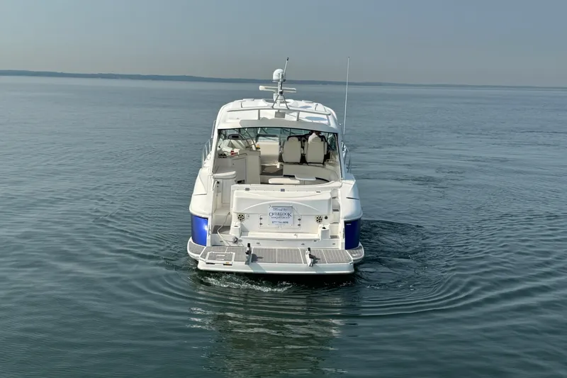 Slide: The Image of 2006 Cruisers Yachts 520 Express on calm water, rear view showcasing spacious deck. - 5