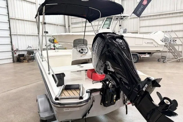 Slide: The Image of 2027 Boston Whaler 130 Super Sport boat with outboard motor in a showroom. - 5