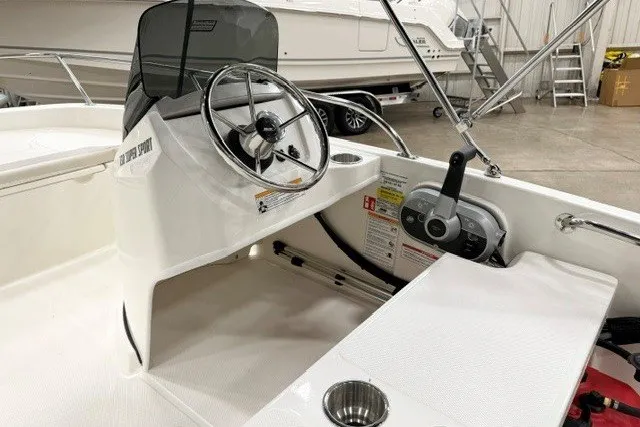 Slide: The Image of 2027 Boston Whaler 130 Super Sport boat interior with steering wheel and control panel. - 8