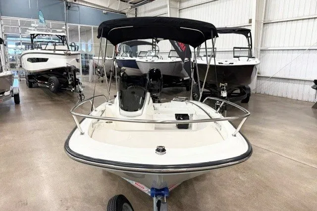 Slide: The Image of 2027 Boston Whaler 130 Super Sport boat displayed in a showroom with other boats. - 9