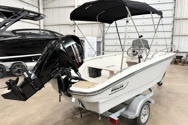 Slide: The Image of 2027 Boston Whaler 130 Super Sport boat with Mercury engine in a showroom. - 4