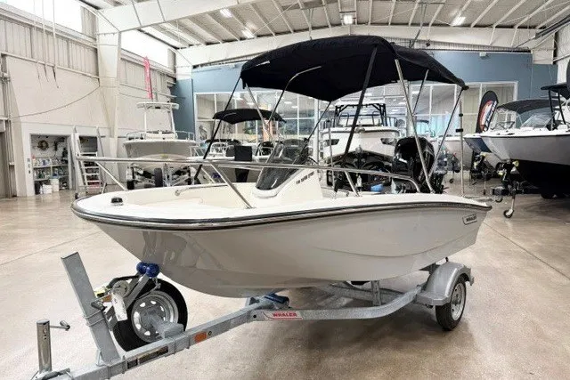 Slide: The Image of 2027 Boston Whaler 130 Super Sport boat displayed indoors on a trailer. - 1