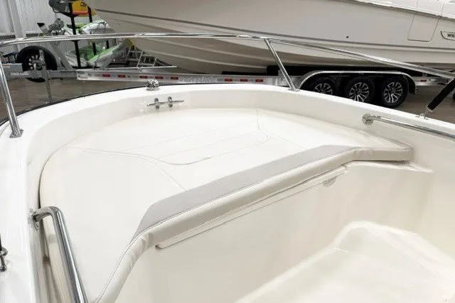 Slide: The Image of 2027 Boston Whaler 130 Super Sport boat interior with sleek white seating and stainless steel rails. - 11