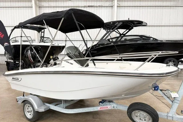 Slide: The Image of 2027 Boston Whaler 130 Super Sport boat on trailer in showroom. - 2
