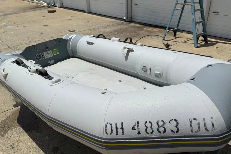 Slide: The Image of 2004 Zodiac Cadet Fastroller 310 FR Acti-V inflatable boat on concrete surface. - 13