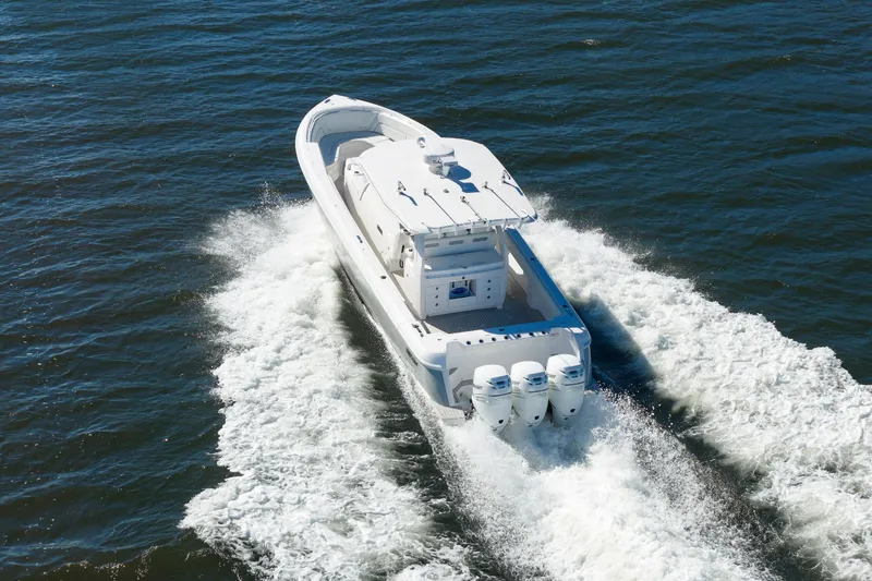 Slide: The Image of 2021 Intrepid 407 Nomad SE boat cruising on open water, rear view. - 3