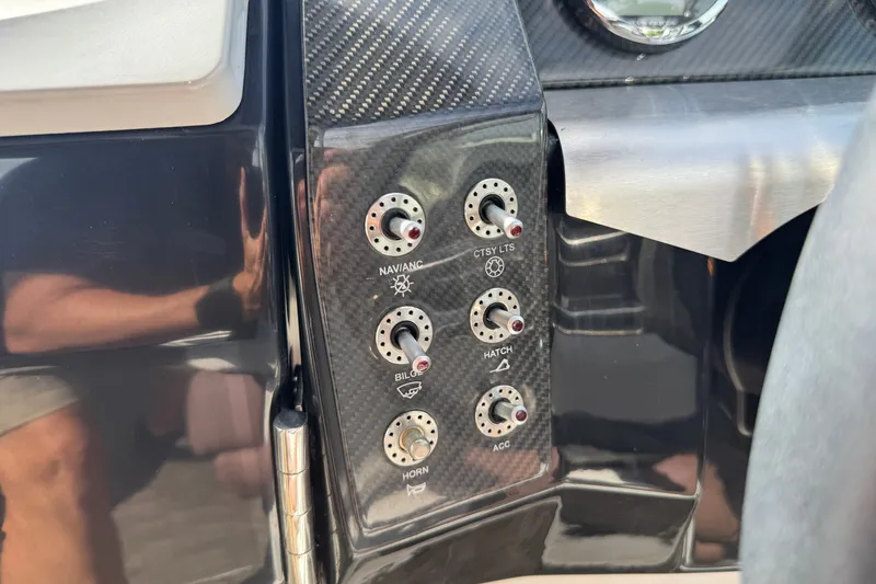 Slide: The Image of Control panel of a 2017 Four Winns H290 boat with various switches. - 22
