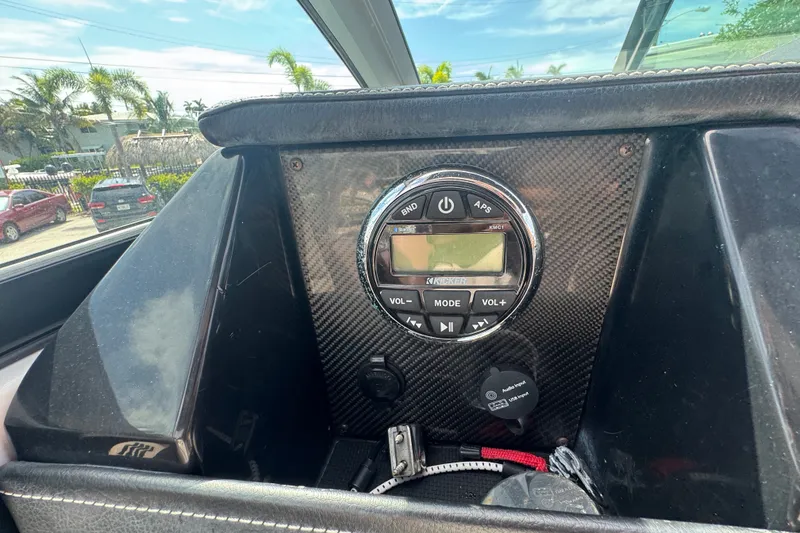 Slide: The Image of Dashboard of a 2017 Four Winns H290 boat featuring a Kicker audio system. - 25