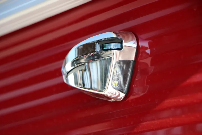 Slide: The Image of Close-up of a 2026 Bennington 22 SSR Tri-Toon boat's sleek chrome detail on red exterior. - 8