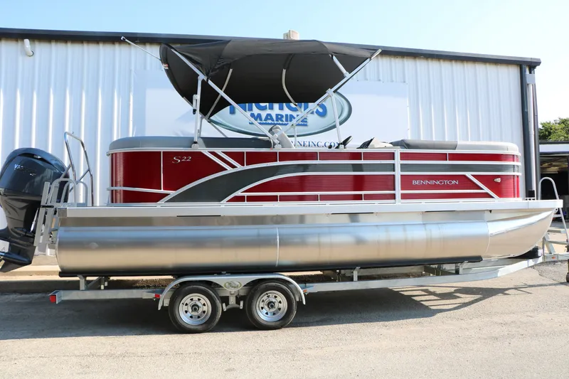 Slide: The Image of 2026 Bennington 22 SSR Tri-Toon pontoon boat on trailer, featuring sleek red design. - 1