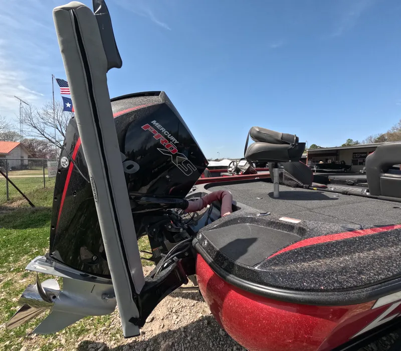 Slide: The Image of 2019 Nitro Z19 boat with Mercury Pro XS engine, parked outdoors under clear sky. - 19