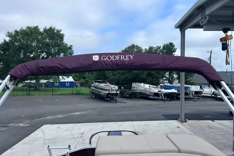 Slide: The Image of 2021 Godfrey Sweetwater 2086 C pontoon boat with maroon canopy in a marina setting. - 27