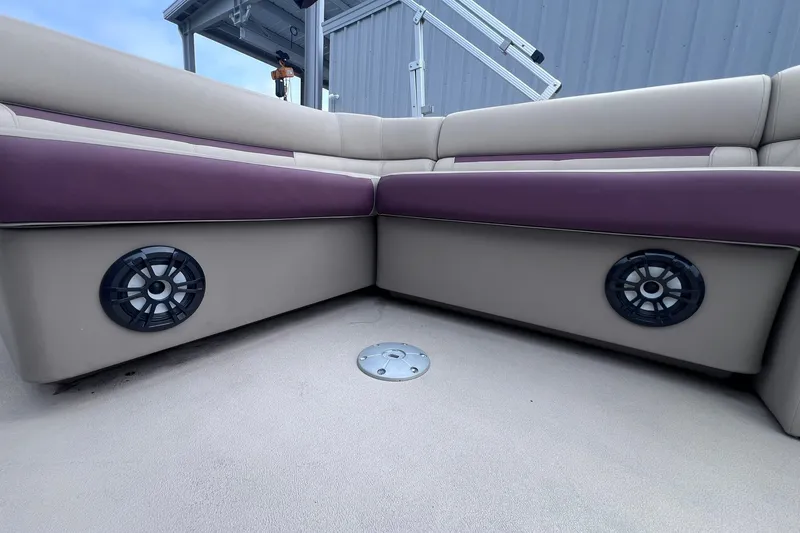 Slide: The Image of 2021 Godfrey Sweetwater 2086 C boat interior with beige and purple seating, featuring built-in speakers. - 25