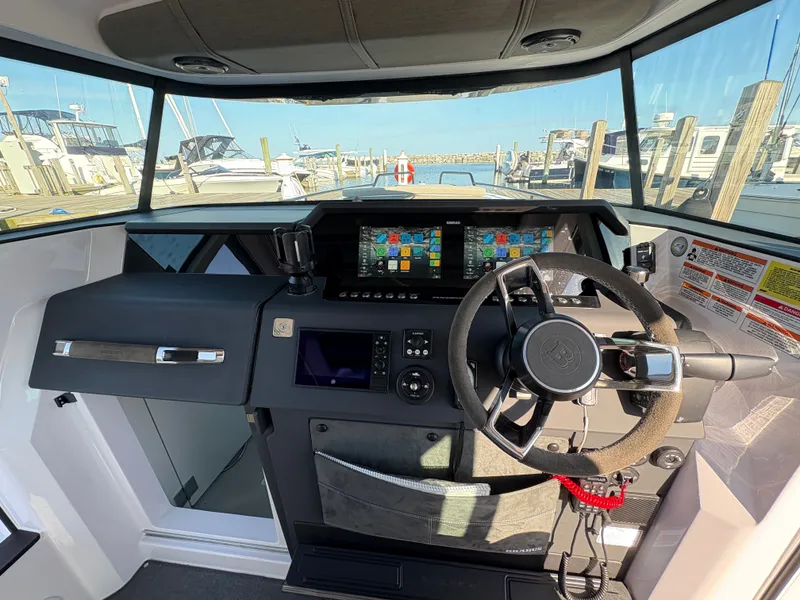 Slide: The Image of The cockpit of the 2024 Axopar 37 XC Cross Cabin features a modern helm with multiple screens. - 19