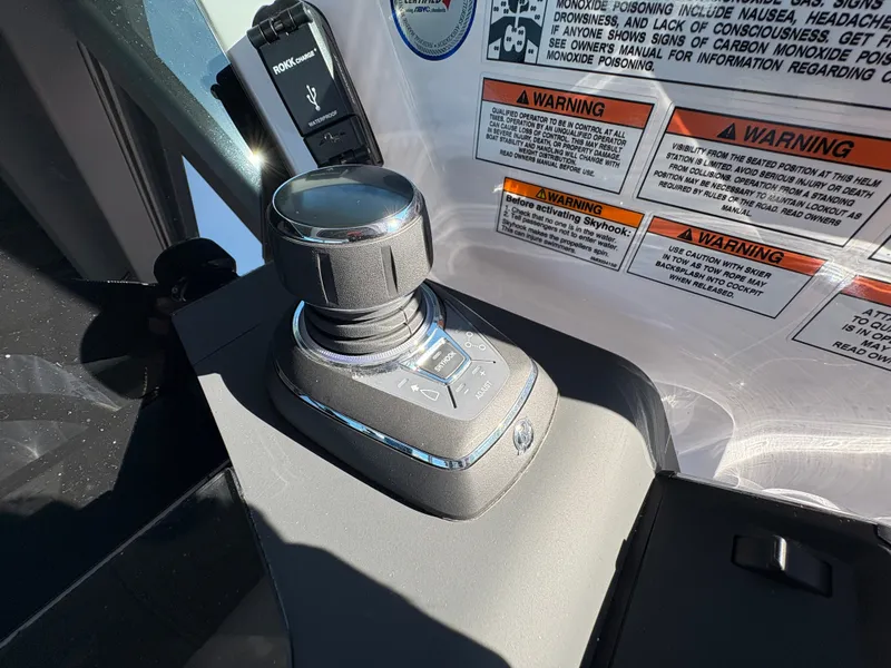 Slide: The Image of Joystick control in the 2024 Axopar 37 XC Cross Cabin, surrounded by warning labels. - 22
