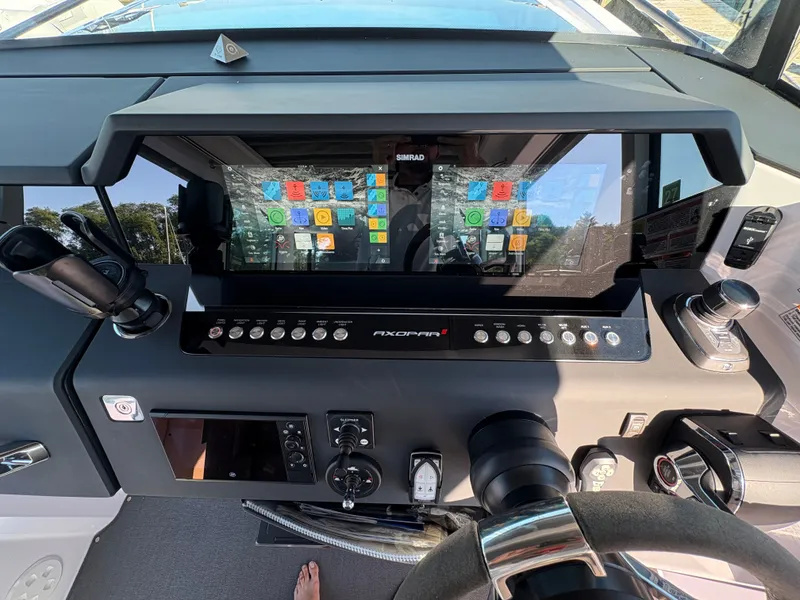 Slide: The Image of The image shows the cockpit of a 2024 Axopar 37 XC Cross Cabin with modern instruments. - 23