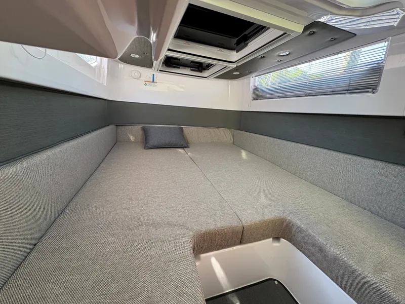 Slide: The Image of Interior of a 2024 Axopar 37 XC Cross Cabin with gray upholstery and a window. - 14