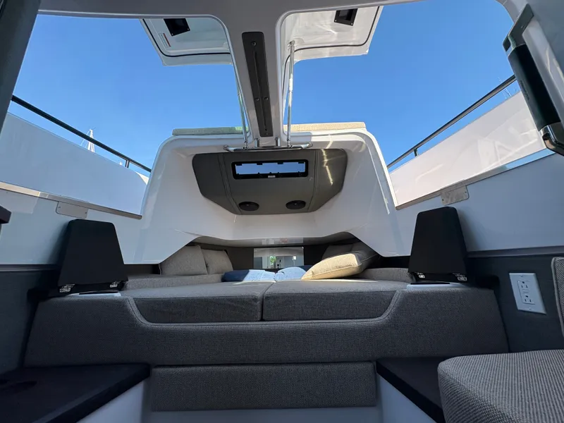 Slide: The Image of Interior of the 2024 Axopar 37 XC Cross Cabin with a lounging area and skylight. - 33