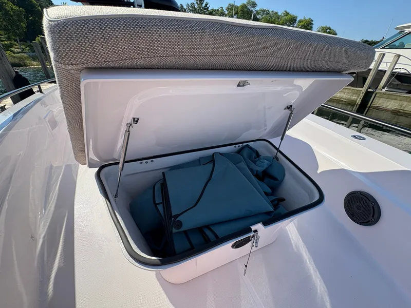 Slide: The Image of An open storage compartment on an Axopar 37 XC Cross Cabin boat, filled with blue bags. - 40