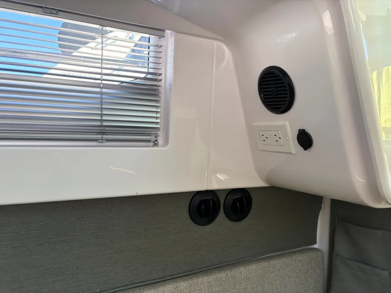 Slide: The Image of Interior of a boat with window blinds, an electrical outlet, and a speaker. - 16