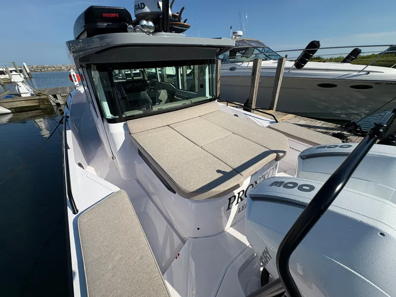 Slide: The Image of 2024 Axopar 37 XC Cross Cabin at dock with twin outboard engines and sunbed. - 45
