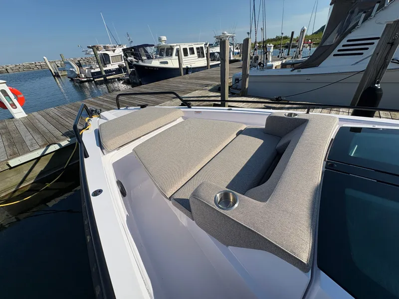 Slide: The Image of The 2024 Axopar 37 XC Cross Cabin is docked. It features comfortable seating and a cup holder. - 37