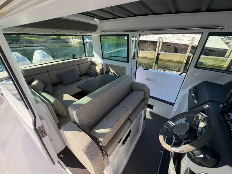 Slide: The Image of Interior of a 2024 Axopar 37 XC Cross Cabin with gray seating and a helm station. - 18