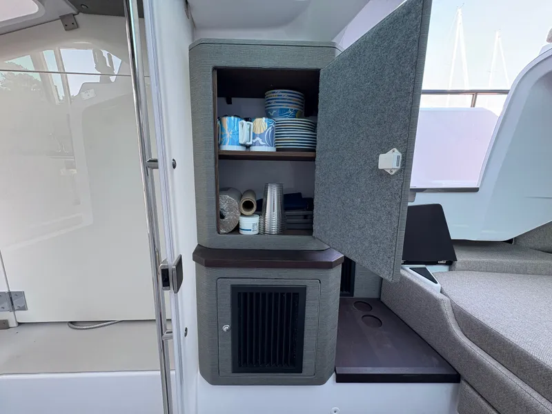 Slide: The Image of The 2024 Axopar 37 XC Cross Cabin features an interior cabinet with dishes and cups. - 34
