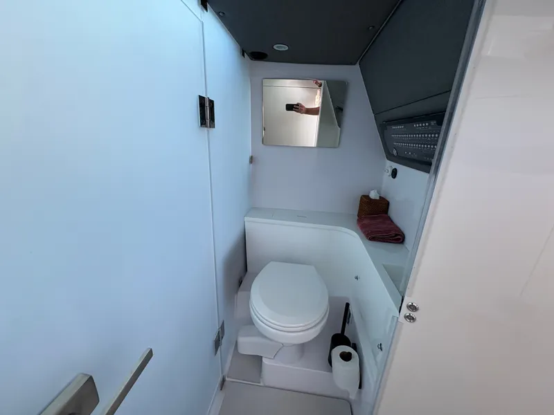 Slide: The Image of The image shows a modern yacht bathroom with a toilet, mirror, and sink. - 28