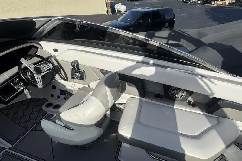 Slide: The Image of 2019 Four Winns HD240 Surf boat interior with steering wheel and seating. - 4