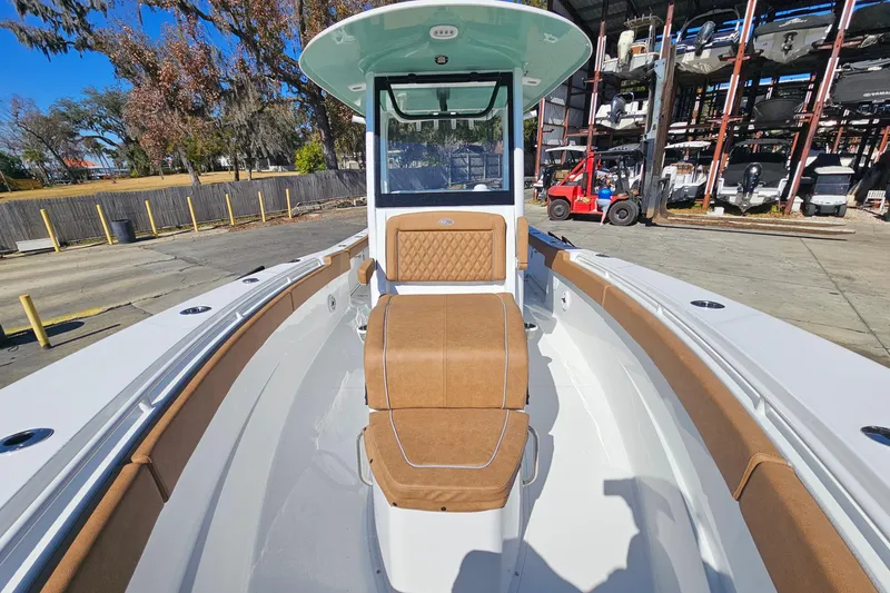 Slide: The Image of 2026 Sea Hunt Ultra 275 Coffin Box boat with tan seating, docked outdoors. - 24