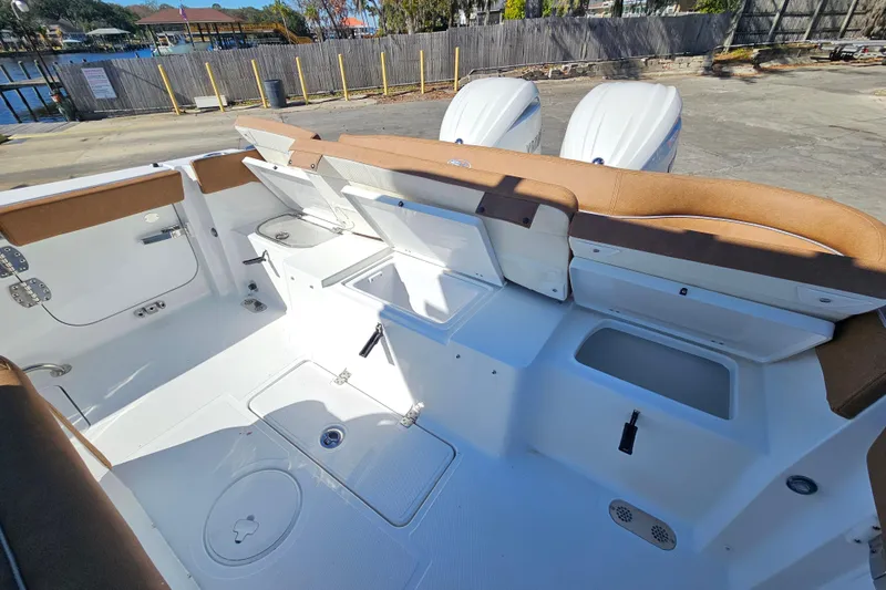 Slide: The Image of 2026 Sea Hunt Ultra 275 Coffin Box boat interior with storage compartments and twin engines. - 13