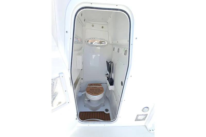 Slide: The Image of 2026 Sea Hunt Ultra 275 Coffin Box boat interior with compact marine toilet. - 28