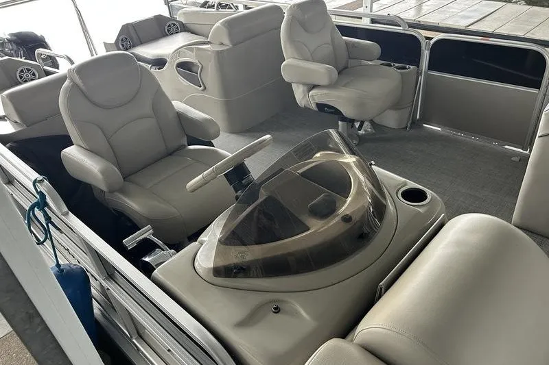 Slide: The Image of 2015 South Bay 524 SLTT pontoon boat interior with plush seating and steering console. - 11