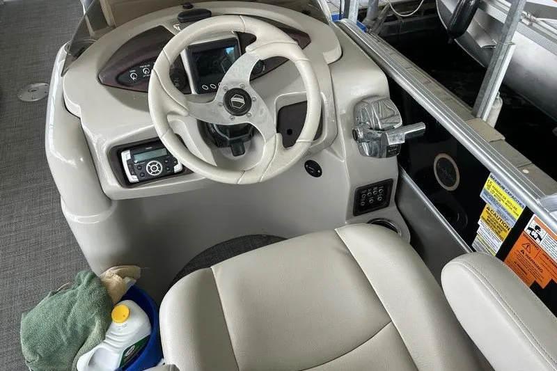 Slide: The Image of Steering console of a 2015 South Bay 524 SLTT boat with controls and seat. - 12