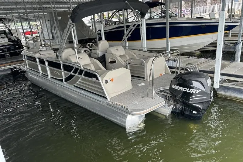 Slide: The Image of 2015 South Bay 524 SLTT pontoon boat with Mercury outboard motor docked in marina. - 2