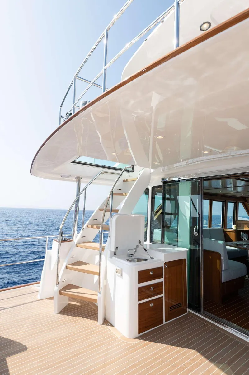 Slide: The Image of The 2020 Hunt Yachts Ocean 63 Flybridge features an elegant staircase and a modern outdoor kitchen. - 16