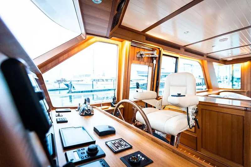Slide: The Image of Interior view of a luxury yacht helm station with wood paneling and white seats. - 37